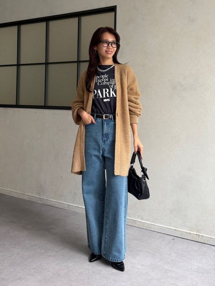 ベージュのロングカーディガンと黒Tシャツ、ブルーデニムのコーデ