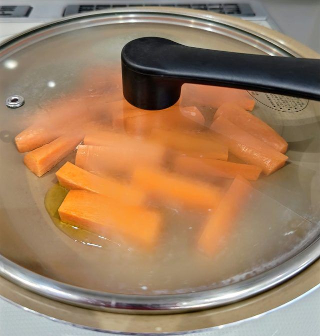 フライパンでにんじんを蒸し焼きにしている様子