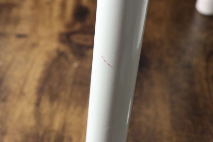 白い椅子の脚に付着した、ピンク色の油性ペンらしき汚れのアップ