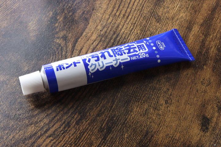 木目調のテーブルに置かれた、青と白の「ボンド 汚れ除去用クリーナー」のチューブ本体