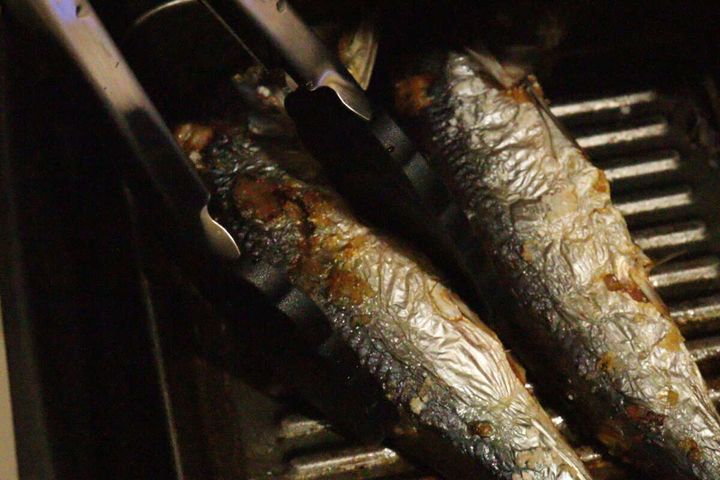 魚焼きグリルで焼かれた魚をダイソーのシリコーントングで優しく掴んでいる様子