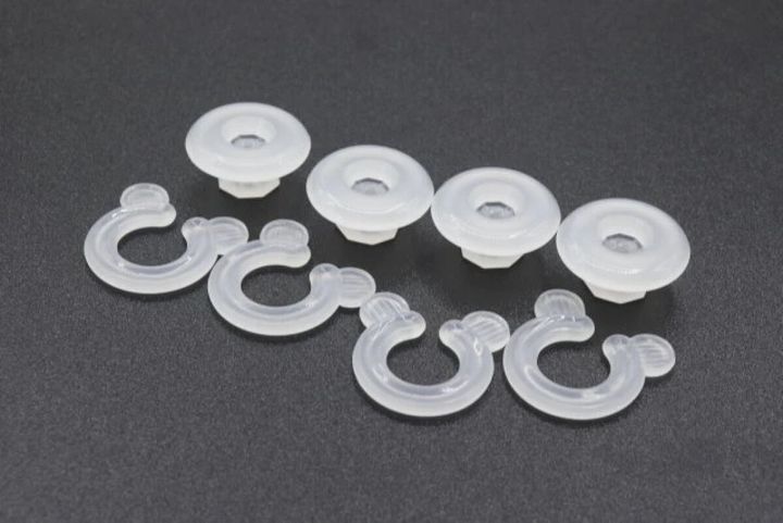 半透明のフック型とボタン型の布団クリップが複数個並べられている