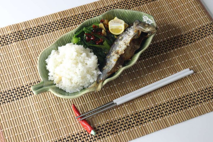 竹ランチョンマットの上に置かれた焼き魚とご飯の和食