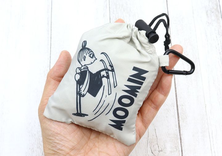 手のひらに、リトルミイのイラストと「MOOMIN」の文字が入った、小さく収納されたエコバッグが乗せられている。