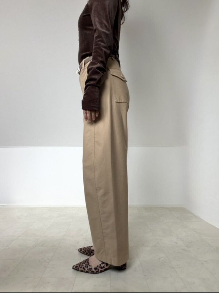 ベージュのバレルレッグパンツとブラウンのベルベットトップスを着た女性の横向き全身