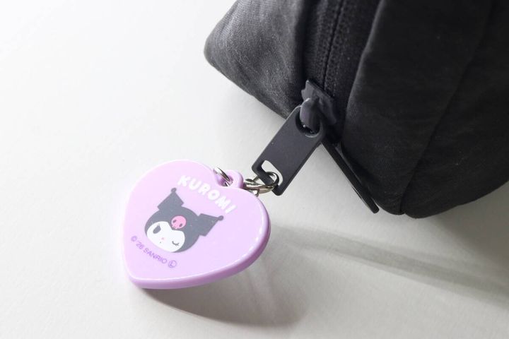 黒いポーチのファスナーの引き手に付けられたクロミのリップミラー