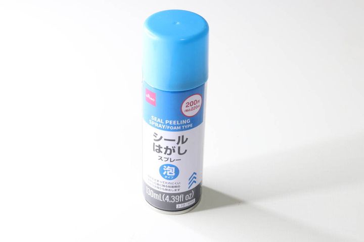 白い背景に置かれた青いキャップのダイソーシールはがしスプレー缶