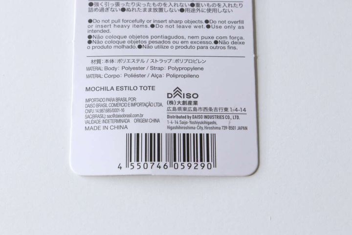 トート型バックパックの商品タグの裏面。バーコード、商品情報、注意書きが詳細に記載されている。