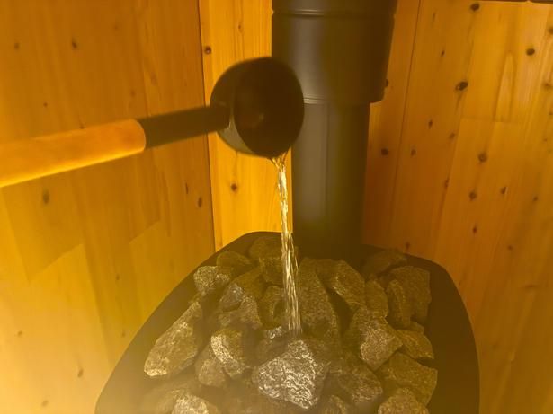 熱したサウナストーンへ柄杓で水をかけてセルフロウリュ。立ち上る蒸気で一気に体感温度が上がる