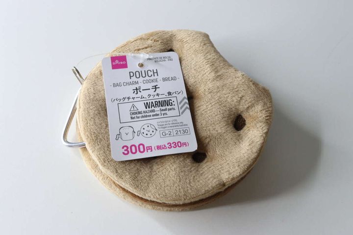 商品タグが付いたクッキー型の茶色いボアポーチが白背景に置かれている