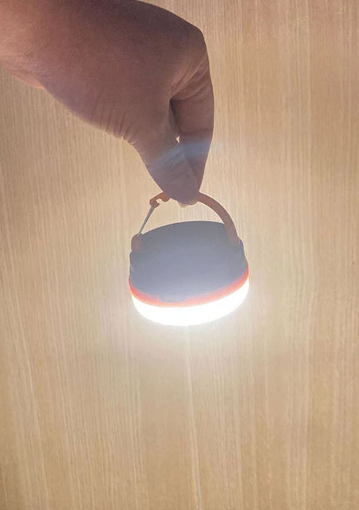 暗い部屋で指でつまんだマルチランタンSが明るく点灯