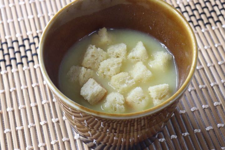 茶色のカップに入ったスープに、たくさんのクルトンが浮かんでいる