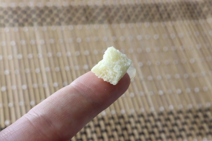 人差し指の先に、四角いクルトンが1粒乗っている