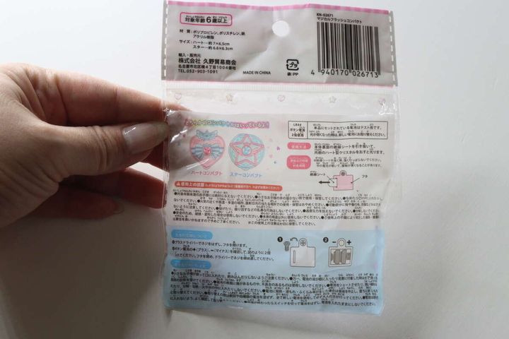 女性の手が持っているマジカルフラッシュコンパクトのパッケージ裏面。注意書きや説明が記載されている