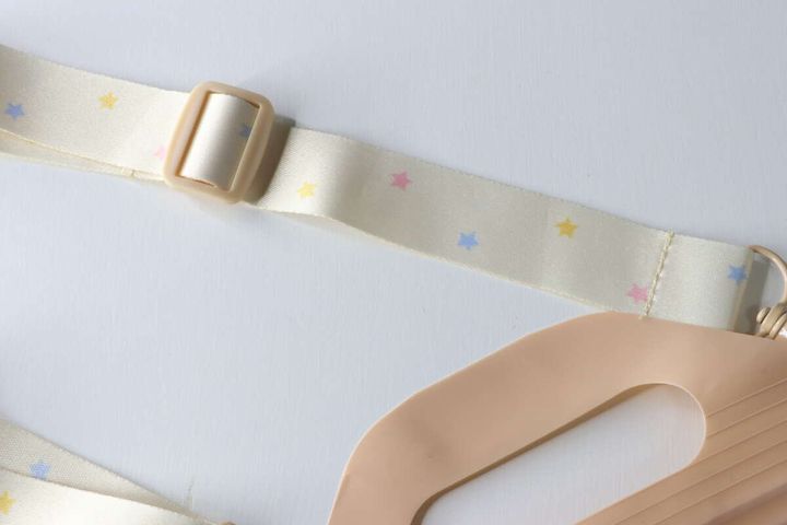 星模様が散りばめられた淡い色のストラップと長さ調節パーツの接写
