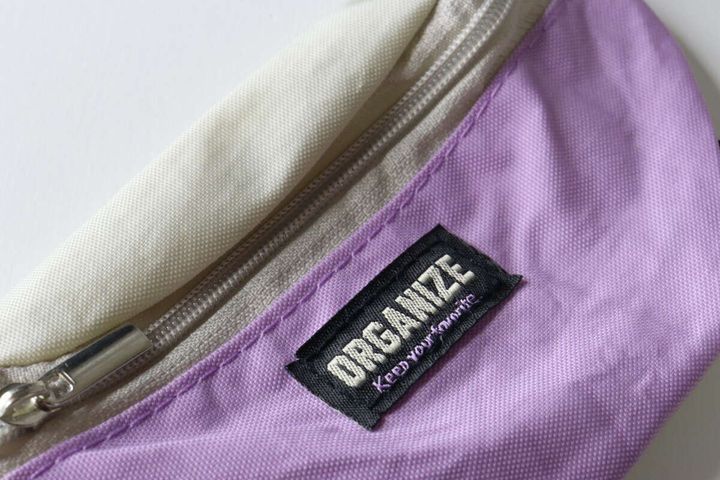 ウエストポーチ風キーホルダーの「ORGANIZE」と書かれた黒いタグ部分のクローズアップ