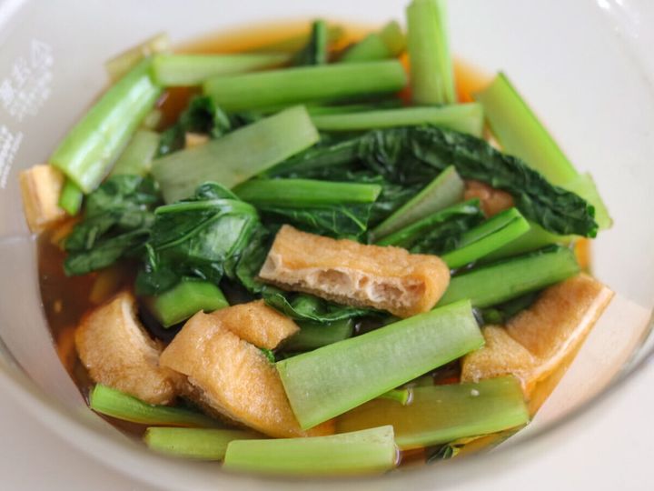 耐熱ボウルの中で調味料と合わせられ加熱された小松菜と油揚げ