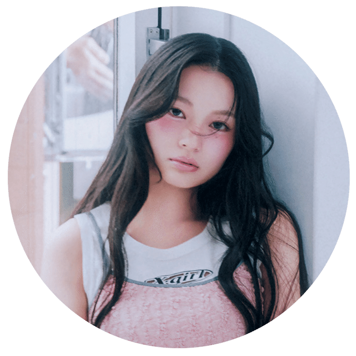 X-girlのロゴ入り白タンクトップにピンクのビスチェを重ね着し、ロングヘアでカメラを見つめる、CANDY TUNE・桐原美月さんのプロフィール用丸型ポートレート写真