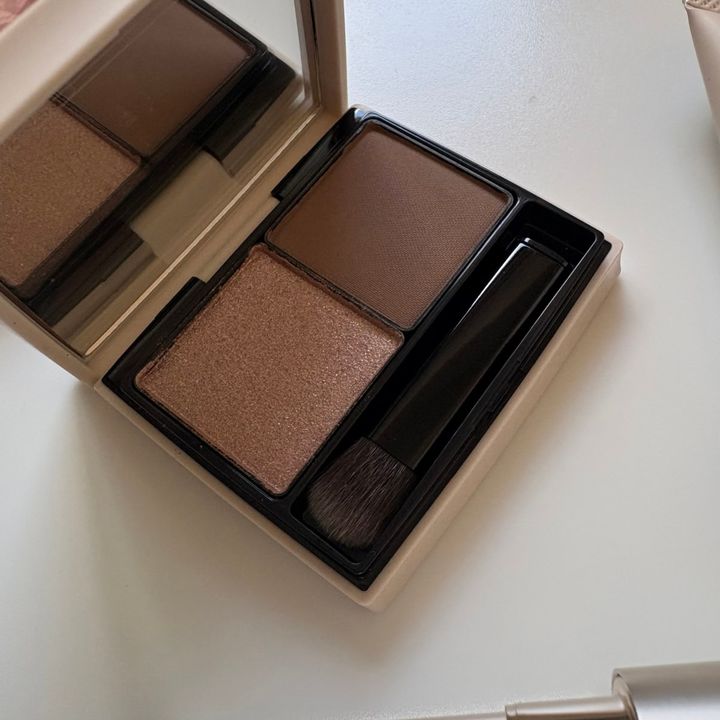 2色アイシャドウパレット「RMK ザ クワイエット プロヴォカター アイズ」のアップ。輝くブロンズブラウン（左）と、マットなダークブラウン（右）がセットされています。