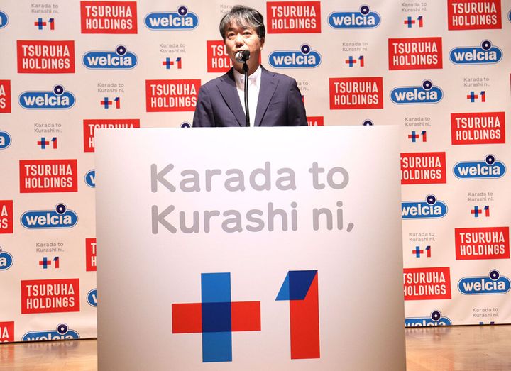 新ブランドの発表会でマイクを手にスピーチをする鶴羽社長