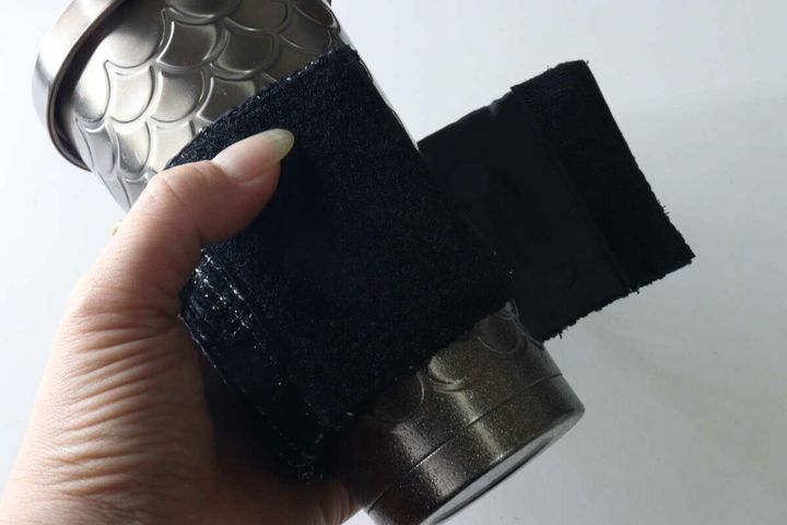 タンブラーにカップスリーブを巻き付けて面ファスナーで留めている手元