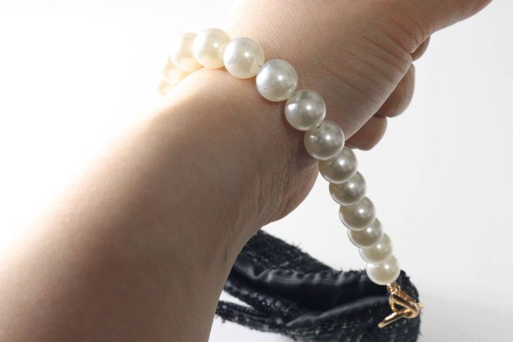 パールストラップを手首に通してバッグのように持ち歩いている様子