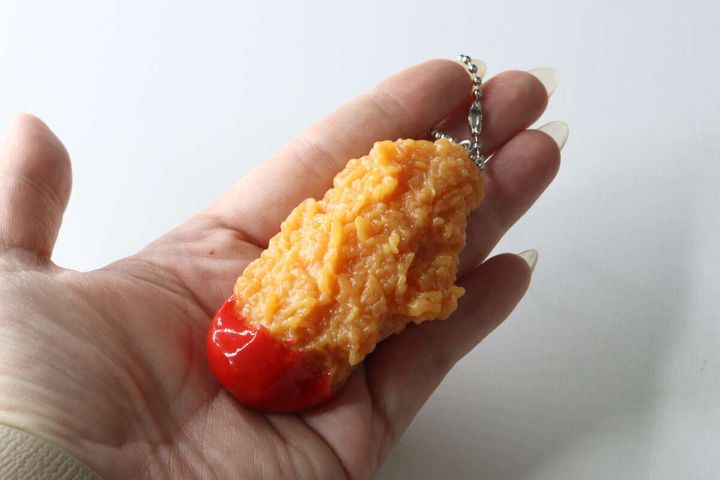 手のひらに乗せられたフライドチキンキーホルダーの全体像