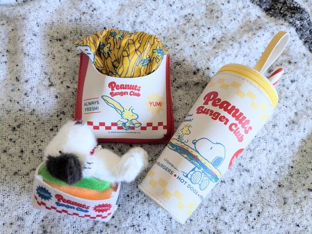 ホットドッグの上でくつろぐスヌーピーのぬいぐるみチャーム