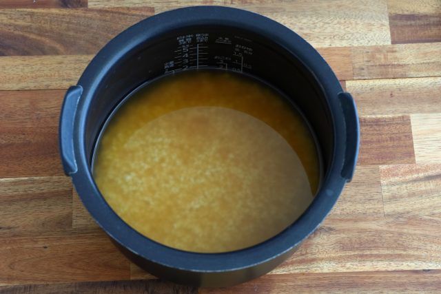 炊飯器に米と調味料、水を加えて混ぜる