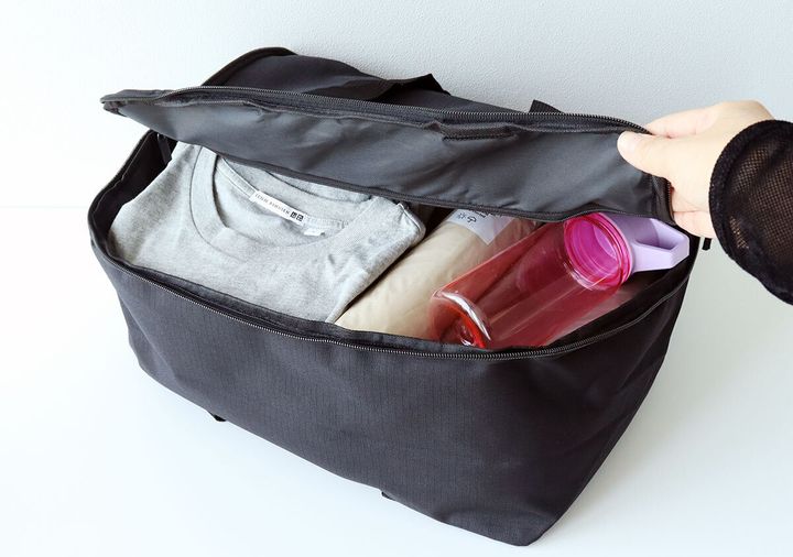 上部を少し開けてトートバッグのように使い衣類やボトルを入れている様子