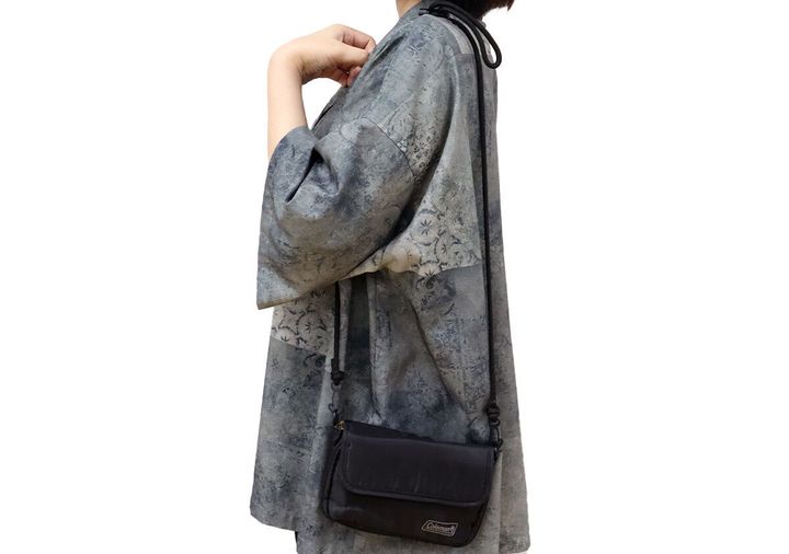 グレーのチュニックにショルダーバッグを斜め掛けした女性の横姿