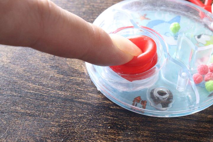 赤いボタンを指で押して水流を起こしている様子