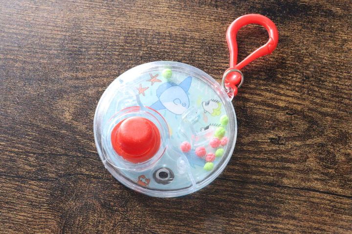 透明な本体に赤いボタンとキーホルダーがついた全体像