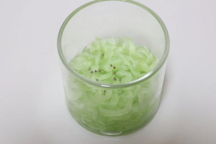 透明な容器に入れた栽培ファイバーの繊維の上に小さな種がいくつかまかれている状態