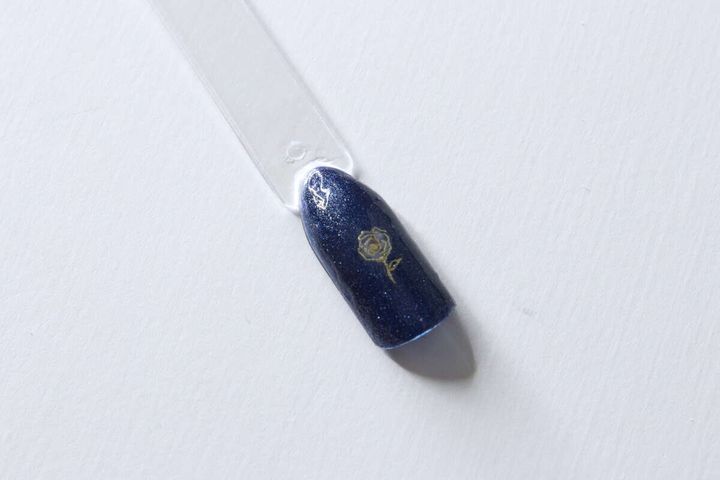トップコートを塗り終えてきれいに仕上がった薔薇デザインのネイルチップ