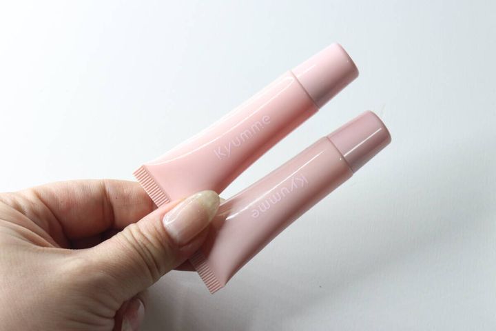 ピンク色のチューブに入ったリップセラム2本を女性が手に持って見せている状態