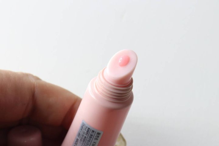 リップセラムのチューブの先端からほんのりピンク色の美容液が出ている状態