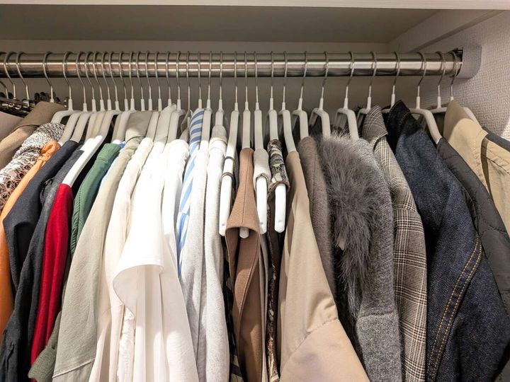 ハンガーに洋服がぎっしりと掛けられたクローゼットの様子