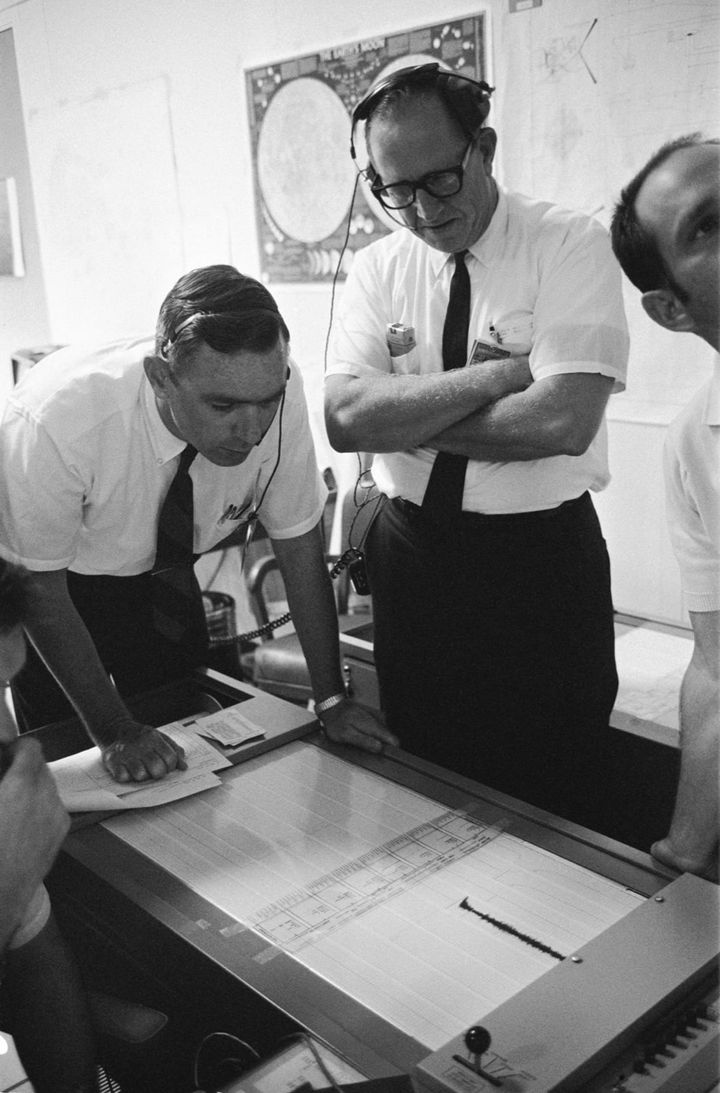 1969年7月20日に管制センターで、アポロ11号の飛行士が月面に置いたばかりの地震計の記録を調べるゲーリー・レイサム博士(左)です。この地震計は隕石がぶつかる揺れや月震を測るためのもので、その記録から月の内部のつくりを探ることが期待されていました。