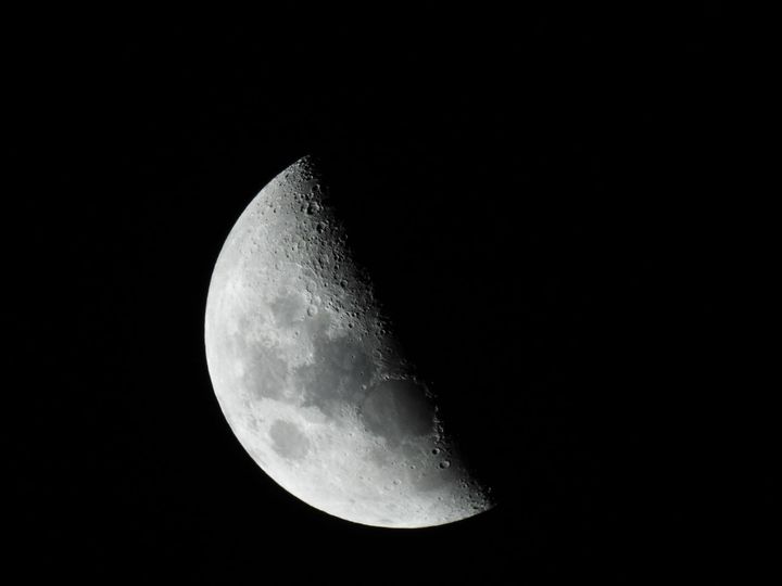 半分ほどが光って見える月を写した写真です。いつ見ても変わらないように見える月の表面にも、縮んだ跡が「しわ」のような崖として残っています。