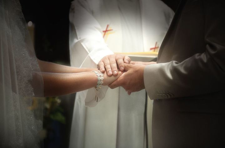 新郎新婦の手に手を重ね、祝福している手元