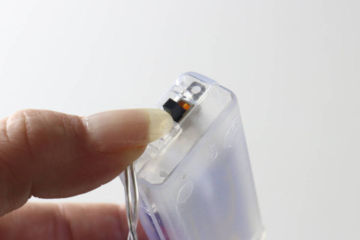 指で電池ボックスのON/OFFスイッチを操作している様子