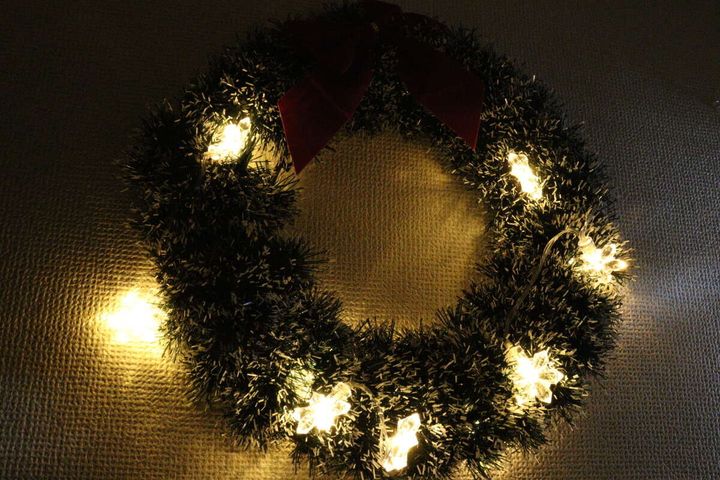 クリスマスリースに飾られた雪の結晶ライトが点灯している