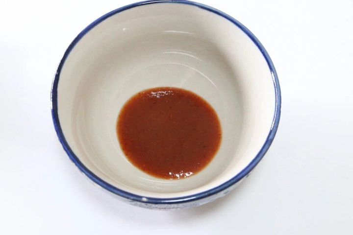 白いお椀の底に赤茶色のスリラチャソースが少量入っている