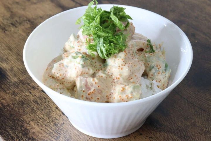 白い丼ぶりに盛られたサーモンサラダ丼。刻みネギが乗っている