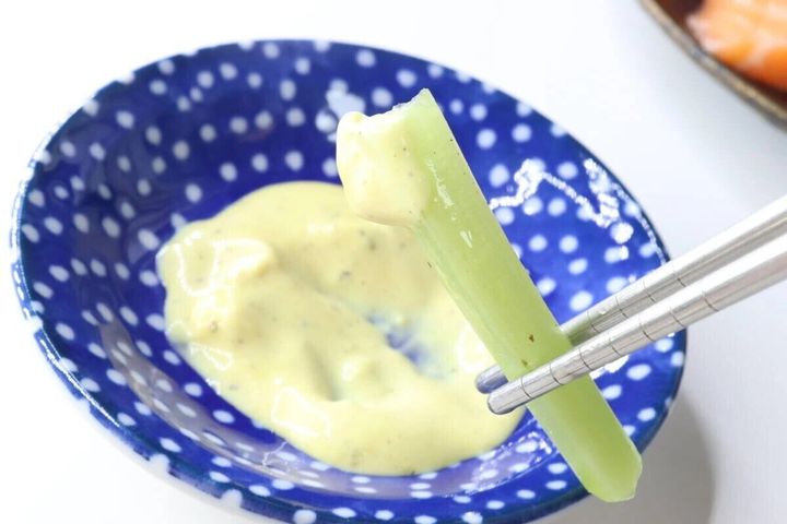 青い小鉢に入ったエリソースに野菜スティックをつけている