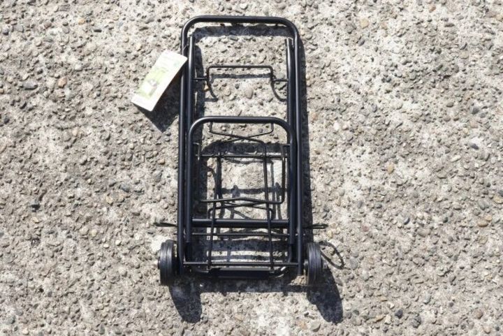 地面に置かれたコンパクトに折りたたまれた状態の黒いキャリー