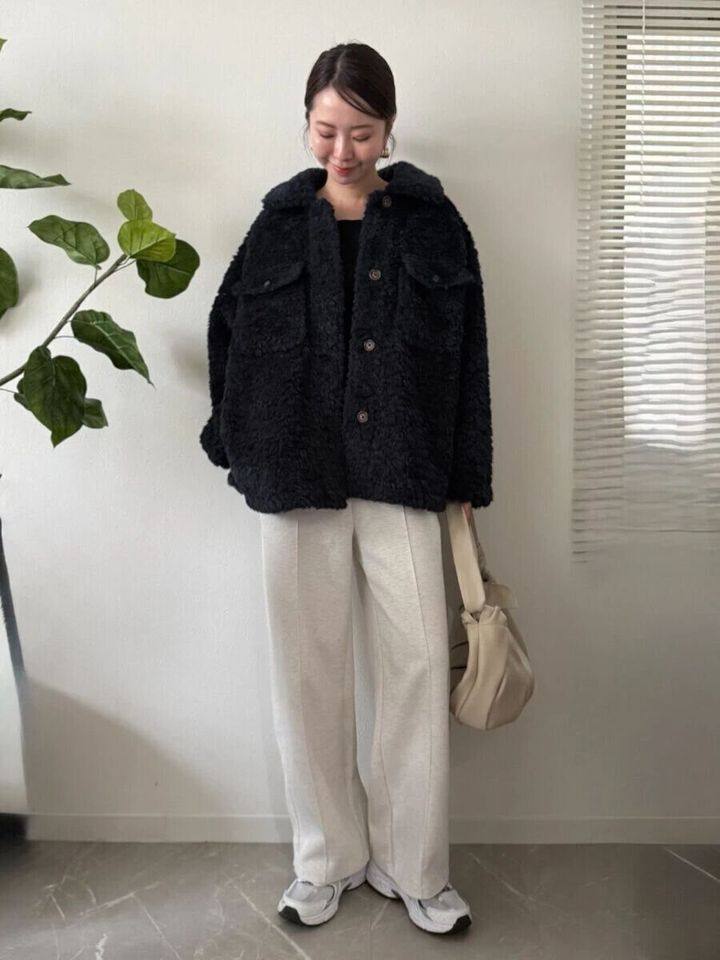 ボアジャケットにスウェットパンツとスニーカーを合わせたカジュアルな女性