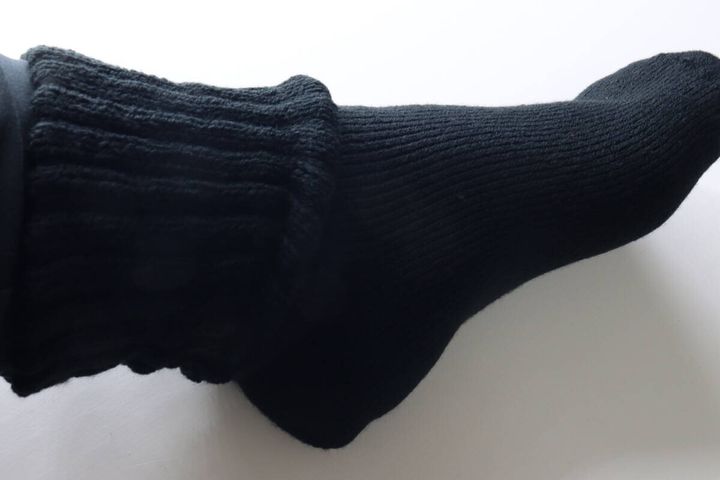 黒いゆったりソックスを履いた足の側面。足首に締め付けがない様子。