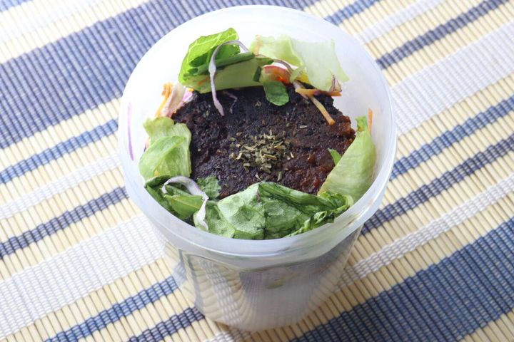 ご飯やハンバーグ、レタスをロコモコ丼風に詰め込んだカップ型ランチボックスの上からの撮影